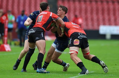 280326 - Fidelity SecureDrive Lions v Dragons RFC, United Rugby Championship - Huw Anderson of Dragons is held by Erich Cronje and Francke Horn of Fidelity SecureDrive Lions