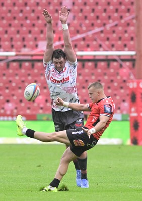 181025 - Emirates Lions v Scarlets - United Rugby Championship - Nico Steyn of the Lions clears under pressure from Alex Groves of Scarlets