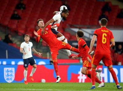 081020 - England v Wales - International Friendly -  Joe Rodon of Wales and Dominic Calvert-Lewin of England compete in the air