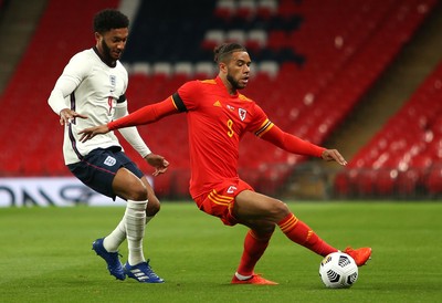 081020 - England v Wales - International Friendly -  Tyler Roberts of Wales is challenged by Joe Gomez of England