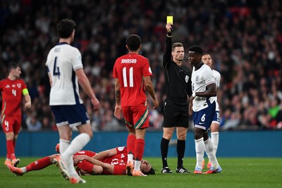 091025 - England v Wales - International Friendly - Mark Guehi of England is shown a yellow card after a foul on Kieffer Moore of Wales