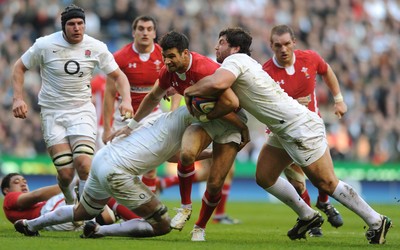 250212 - England v Wales - RBS Six Nations 2012 -Mike Phillips of Wales is tackled by Geoff Parling and Alex Corbisiero of England