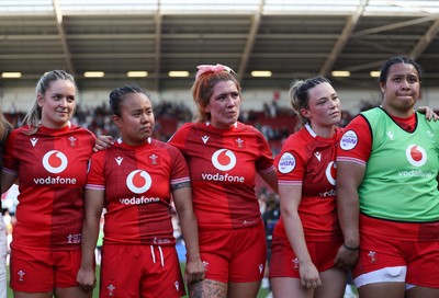 250426 - England v Wales, 2026 Guinness Women’s 6 Nations - Freya Bell of Wales, Jenna De Vera of Wales, Georgia Evans of Wales, Alisha Joyce of Wales and Sisilia Tuipulotu of Wales listen to Sean Lynn, Wales Women head coach at the end of the match