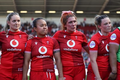 250426 - England v Wales, 2026 Guinness Women’s 6 Nations - Freya Bell of Wales, Jenna De Vera of Wales, Georgia Evans of Wales, Alisha Joyce of Wales and Sisilia Tuipulotu of Wales listen to Sean Lynn, Wales Women head coach at the end of the match