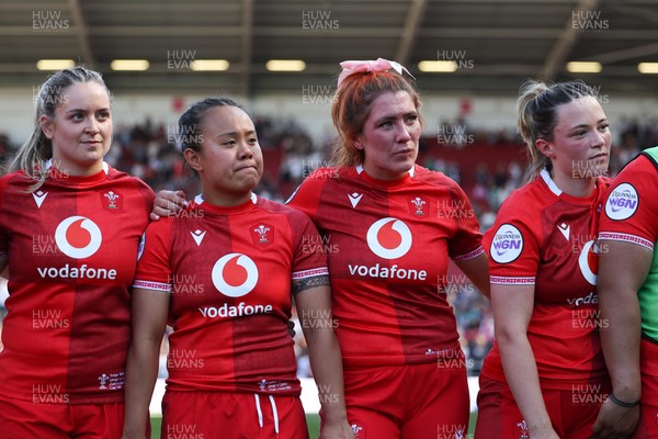 250426 - England v Wales, 2026 Guinness Women’s 6 Nations - Freya Bell of Wales, Jenna De Vera of Wales, Georgia Evans of Wales, Alisha Joyce of Wales and Sisilia Tuipulotu of Wales listen to Sean Lynn, Wales Women head coach at the end of the match