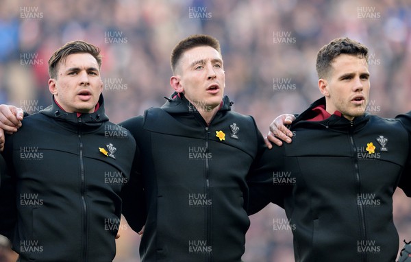 260222 - England v Wales - Guinness Six Nations 2022 - Taine Basham, Josh Adams and Kieran Hardy of Wales during the anthems