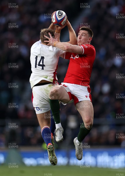 260222 - England v Wales - Guinness 6 Nations - Max Malins of England and Josh Adams of Wales grapple for the ball in the air