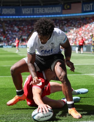 040726 - Fiji v Wales, Nations Championship - Josh Adams of Wales reaches between the legs of Selestino Ravutaumada of Fiji to score try