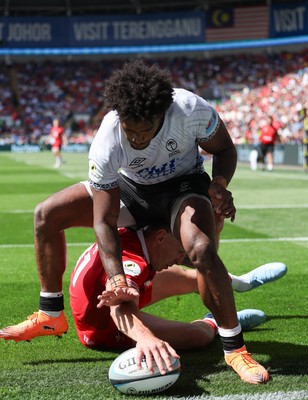 040726 - Fiji v Wales, Nations Championship - Josh Adams of Wales reaches between the legs of Selestino Ravutaumada of Fiji to score try