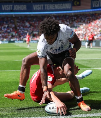 040726 - Fiji v Wales, Nations Championship - Josh Adams of Wales reaches between the legs of Selestino Ravutaumada of Fiji to score try