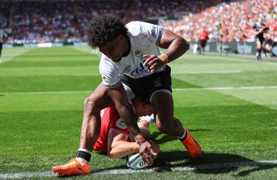 040726 - Fiji v Wales, Nations Championship - Josh Adams of Wales reaches between the legs of Selestino Ravutaumada of Fiji to score try