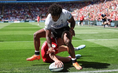 040726 - Fiji v Wales, Nations Championship - Josh Adams of Wales reaches between the legs of Selestino Ravutaumada of Fiji to score try