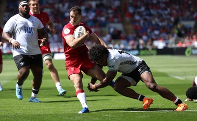 040726 - Fiji v Wales, Nations Championship - Tomos Williams of Wales is tackled just short of the line