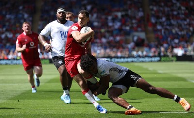040726 - Fiji v Wales, Nations Championship - Tomos Williams of Wales is tackled just short of the line