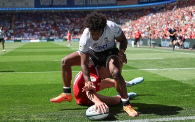040726 - Fiji v Wales, Nations Championship - Josh Adams of Wales reaches between the legs of Selestino Ravutaumada of Fiji to score try