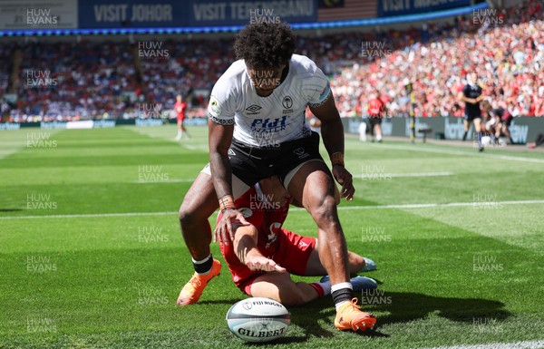 040726 - Fiji v Wales, Nations Championship - Josh Adams of Wales reaches between the legs of Selestino Ravutaumada of Fiji to score try
