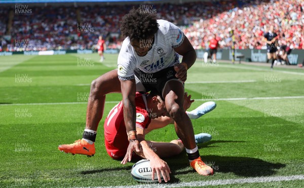 040726 - Fiji v Wales, Nations Championship - Josh Adams of Wales reaches between the legs of Selestino Ravutaumada of Fiji to score try