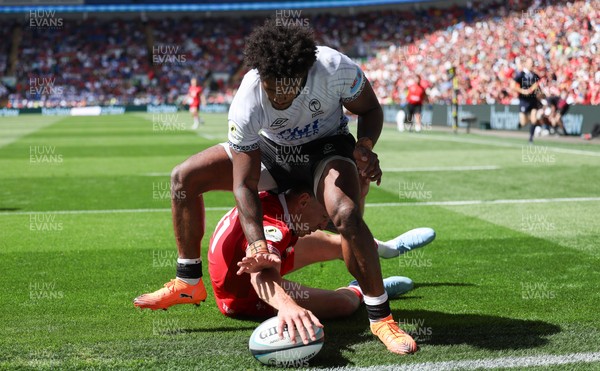 040726 - Fiji v Wales, Nations Championship - Josh Adams of Wales reaches between the legs of Selestino Ravutaumada of Fiji to score try