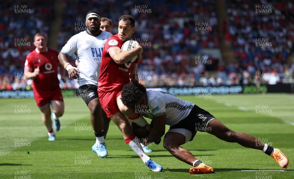 040726 - Fiji v Wales, Nations Championship - Tomos Williams of Wales is tackled just short of the line
