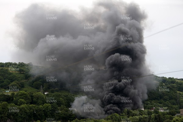 130618 - Picture shows the black smoke coming from Pentrebach Road, Pontypridd Where locals have said the fire started in a scrap metal yard Loud bangs have been heard from across the town