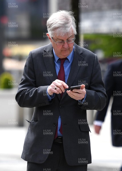 120521 - First Day of Welsh Parliament at the Senedd in Cardiff Bay - Mark Drakeford MS uses his phone during the first day of Welsh Parliament at the Senedd in Cardiff Bay