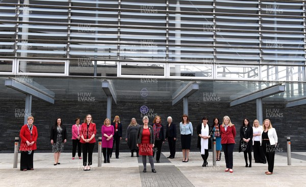 120521 - First Day of Welsh Parliament at the Senedd in Cardiff Bay - Welsh Labour female elected members of the Senedd (L-R) Joyce Watson MS, Vikki Howells MS, Dawn Bowden MS, Sarah Murphy MS, Lynne Neagle MS, Carolyn Thomas MS, Julie James MS, Jane Hutt MS, Julie Morgan MS, Jenny Rathbone MS, Lesley Griffiths MS, Rhianon Passmore MS, Eluned Morgan MS, Hannah Blythyn MS, Buffy Williams MS, Rebecca Evans MS and Jayne Bryant MS stand in front of a plaque in remembrance of Valerie Feld during the first day of Welsh Parliament at the Senedd in Cardiff Bay