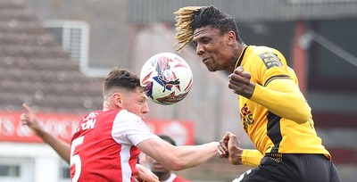 260425 - Fleetwood Town v Newport County - Sky Bet League 2 - Kyle Hudlin of Newport clears the high ball with James Bolton of Fleetwood