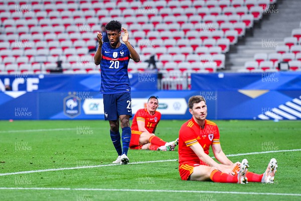 020621 - France v Wales - International Friendly - Kingsley Coman of France celebrates while Welsh players sit on the pitch dejected