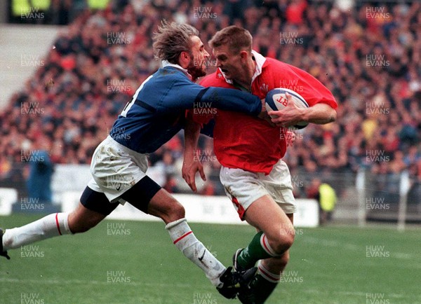 060399 - France v Wales - Five Nations -   Dafydd James of Wales beats the tackle of Philippe Bernat-Salles to score try