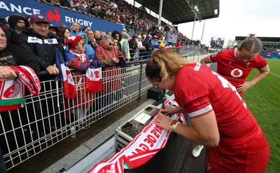 120425 - France v Wales, Guinness Women’s Six Nations 2025 - Courtney Keight of Wales signs a scarf for French supporters at the end of the match