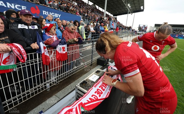 120425 - France v Wales, Guinness Women’s Six Nations 2025 - Courtney Keight of Wales signs a scarf for French supporters at the end of the match