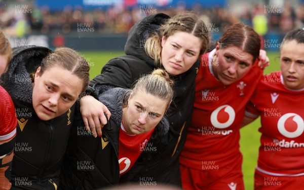 120425 - France v Wales, Guinness Women’s Six Nations 2025 - Jenni Scoble of Wales, Keira Bevan of Wales, Gwen Crabb of Wales, Georgia Evans of Wales and Kayleigh Powell of Wales listen to Wales Women head coach Sean Lynn at the end of the match