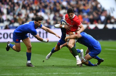 180323 - France v Wales - Guinness Six Nations - Louis Rees-Zammit of Wales is tackled by Gael Fickou and Francois Cros of France 