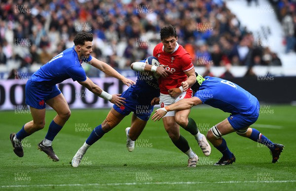 180323 - France v Wales - Guinness Six Nations - Louis Rees-Zammit of Wales is tackled by Gael Fickou and Francois Cros of France 