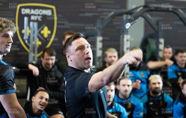 280223 - Gerwyn Price visits the Dragons RFC - Former PDC World Champion and current world number 4 Gerwyn Price plays a game of darts against Dragons Players Darts Champion Joe Westwood as team mates look on during a visit to the team’s training session