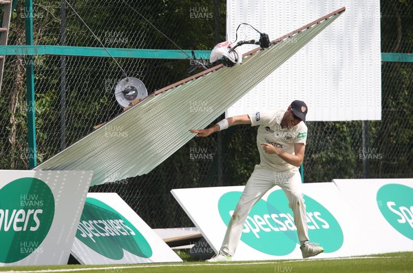 150519 - Glamorgan v Gloucestershire, Specsavers County Championship Division 2, Day 2 - David Payne of Gloucestershire has lucky escape as the sight screen that he was attempting to move collapses towards him