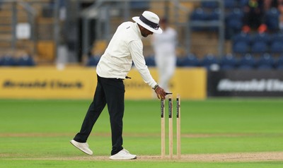 300826 Glamorgan v Hampshire, Rothesay County Championship Division 1 - Umpire Suri Shanmugam checks the light levels before stopping play, firstly for bad light and almost immediately rain