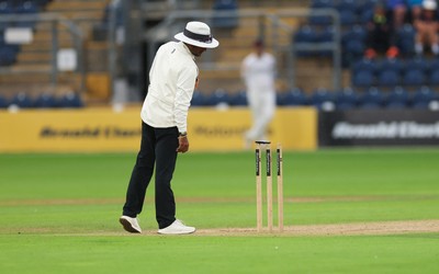 300826 Glamorgan v Hampshire, Rothesay County Championship Division 1 - Umpire Suri Shanmugam checks the light levels before stopping play, firstly for bad light and almost immediately rain