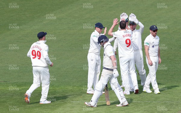 210422 - Glamorgan v Middlesex, LV= County Championship Division 2  - Sam Robson of Middlesex walks away from the wicket after being given out lbw as James Harris of Glamorgan celebrates with team mates