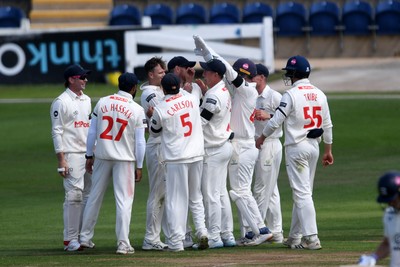 250525 - Glamorgan v Middlesex - Rothesay County Championship - James Harris of Glamorgan celebrates team mates with tafter catching the ball to dismiss Jack Davies of Middlesex