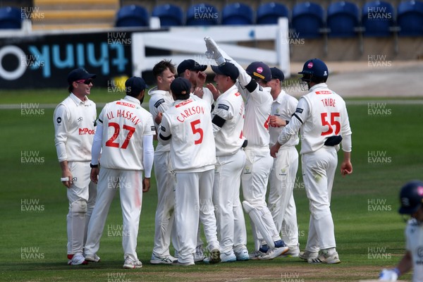 250525 - Glamorgan v Middlesex - Rothesay County Championship - James Harris of Glamorgan celebrates team mates with tafter catching the ball to dismiss Jack Davies of Middlesex