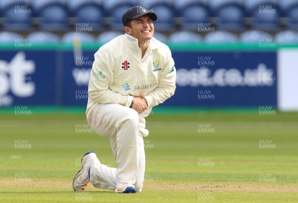 130917 - Glamorgan v Northamptonshire, Specsavers County Championship, Division 2 - Kiran Carlson of Glamorgan shows the pain after stopping the ball