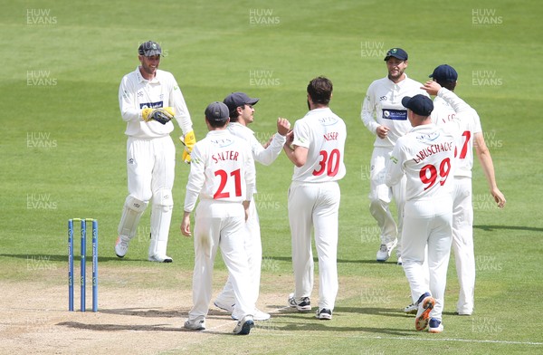 140721 - Glamorgan v Northamptonshire, LV= County Championship - Michael Neser of Glamorgan and Chris Cooke of Glamorgan celebrate with team mates after combining to catch out Emilio Gay of Northamptonshire
