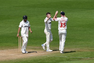 260624 - Glamorgan v Northamptonshire  - Vitality County Championship, Division 2 - Harry Podmore of glamorgan celebrates with teammates after taking the wicket of Justin Broad of Northamptonshire