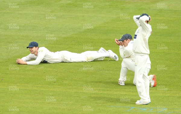 110721 - Glamorgan v Northamptonshire, LV= County Championship - Glamorgan fielders Joe Cooke, David Lloyd and Billy Root react as the ball runs to the boundary for 4 runs