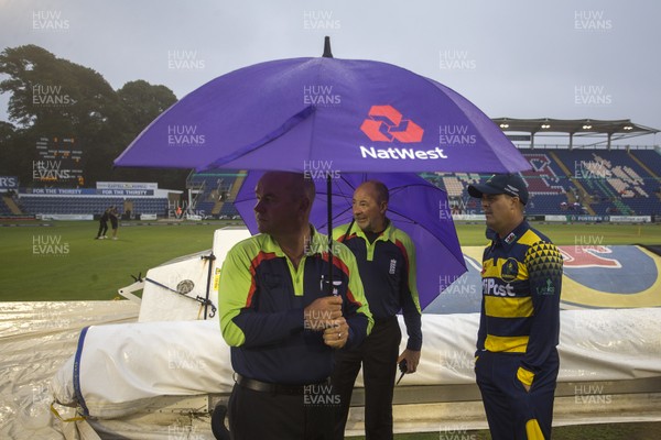 150717 - Glamorgan v Somerset - Natwest T20 Blast - The umpire's stand underneath their umbrella's with Jacque Rudolph