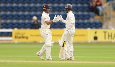 190626 - Glamorgan v Surrey, Rothesay County Championship Division 1- Chris Cooke of Glamorgan and Mason Crane of Glamorgan celebrate their 100 partnership