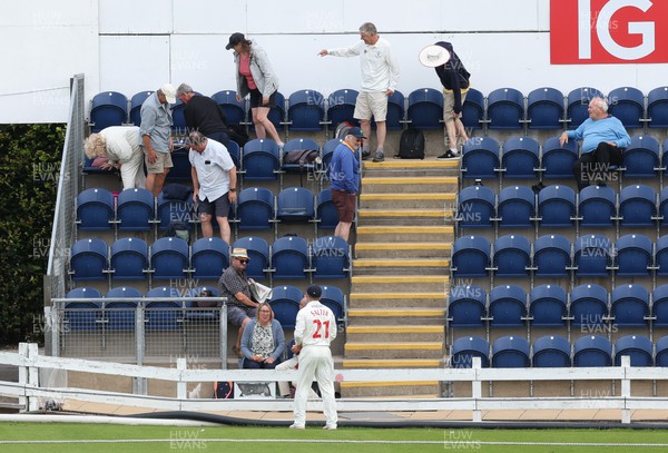 250623 - Glamorgan v Sussex, LV= Insurance County Championship, Div 2 - Spectators look for the ball as Andrew Salter of Glamorgan waits after it is hit into the stand for six runs