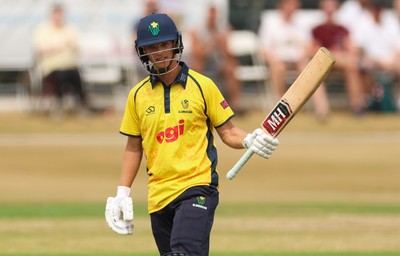 220726 - Glamorgan v Sussex Sharks, Metro Bank One Day Cup - Jack Hope-Bell of Glamorgan raises his bat as he reaches his 50 runs