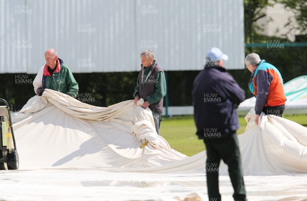 110521 - Glamorgan Second XI v Gloucestershire Second XI, Second XI Championship - Volunteers at Newport Cricket Club remove the covers ahead of play at the ground